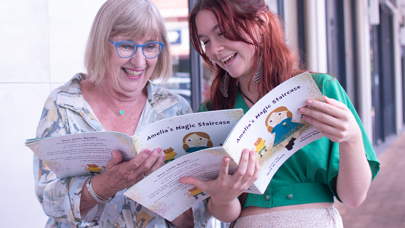 Children's book author and illustrator reading 'Amelia's Magic Staircase' book together.