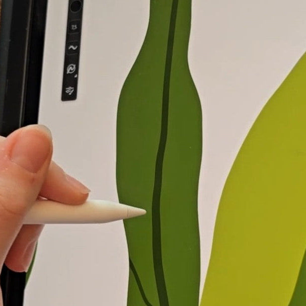 Hand illustrating green leaves digitally on a tablet with a stylus
